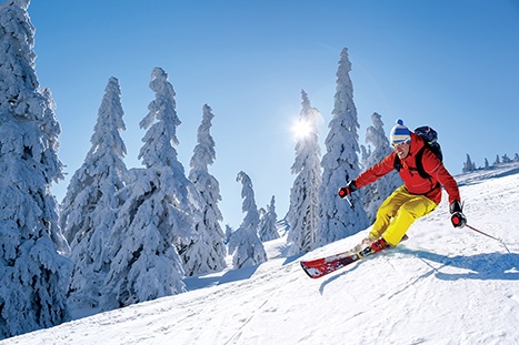 skier-skiing-downhill-in-high-mountains-against-blue-sky